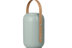 En grön, cylindrisk lampa med ett böjt trähandtag fäst på sidan.